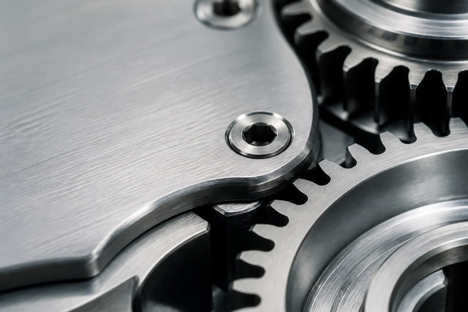 Macro view of metal gear teeth and brushed aluminum hardware.